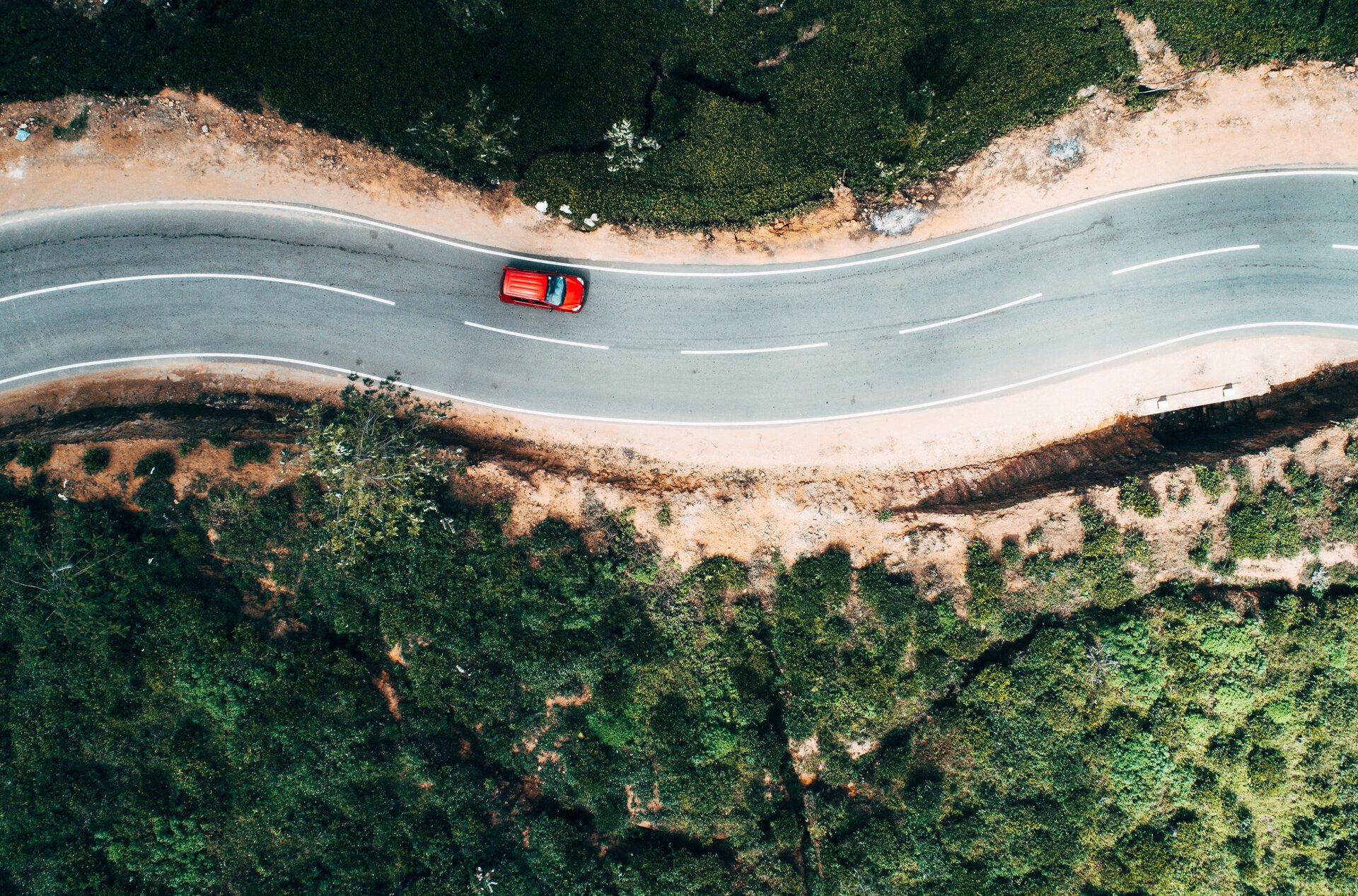 Luchtfoto van een auto op een pittoreske weg.