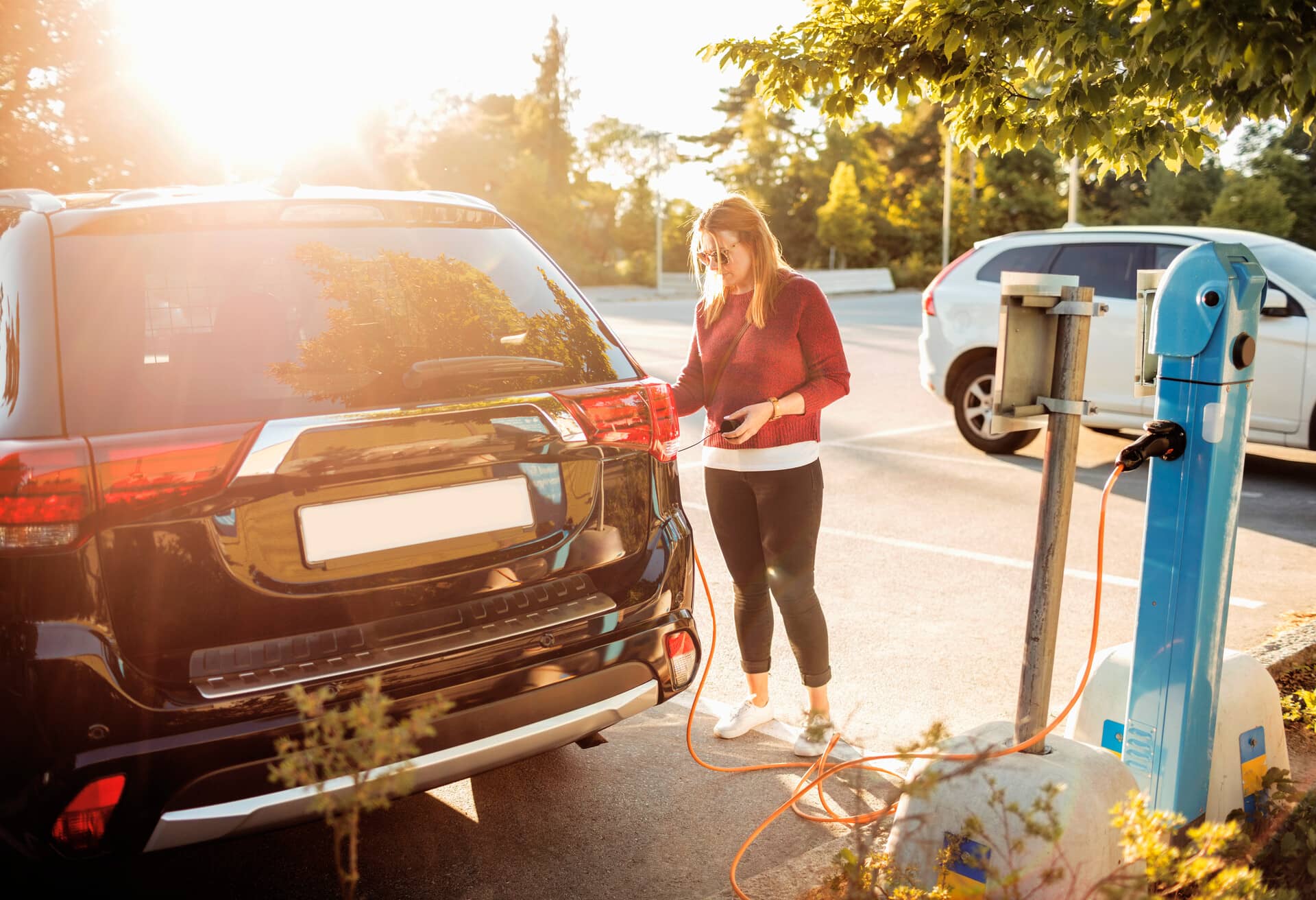 Een meisje dat een elektrische auto oplaadt.