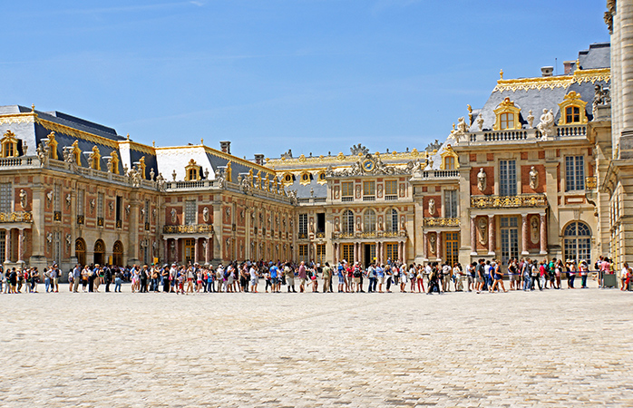 In het zonnetje, in de rij voor het Kasteel van Versailles