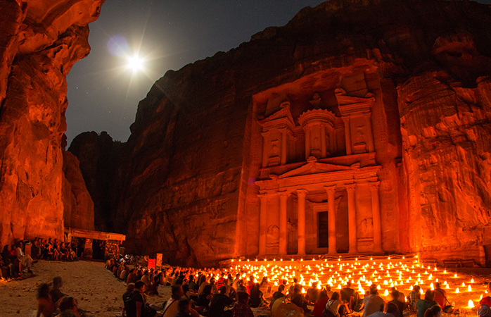 Reizigers verzamelen zich ‘s avonds met kaarsen rond de Al Khaznet tempel. 