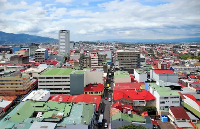 San José, Costa Rica: city center skyline - view along a downtown avenue towards the mountains - several different logos/brands on the respective buildings - photo by M.Torres