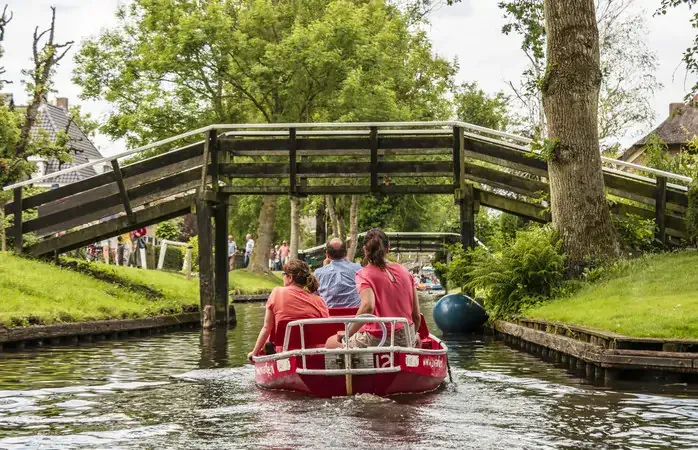 Beautiful dutch canals on a summer day in Giethoorn,Farms with thatched wooden roofs and wooden bridge in Giethoorn, Holland Netherlands June 2017 ; Shutterstock ID 658091929