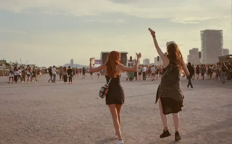 Friends having fun dancing about at a sunny music festival in Barcelona.