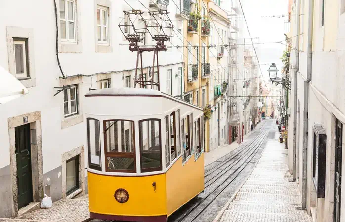 Typical yellow old tram funicular Elevador da Bica in Bairro Alto, going up hill in the old town of Lisbon